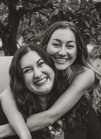 Clarae's arms are around Taressa as the two smile, representing their close relationship as business owners and event planners in Oregon. 