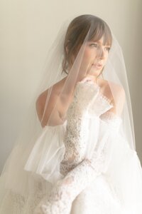Bride wearing a veil, softly lit by sunlight