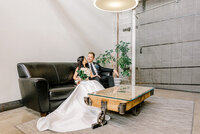 bride and groom sitting together on a couch at The Living Room in Omaha