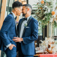 groom and groom embracing one another with foreheads touching at winery reception area