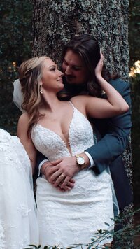 A person standing behind their partner as they reach behind to kiss 