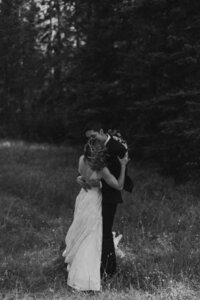 bridal couple embracing in field