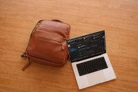 Open laptop and leather bag on floor