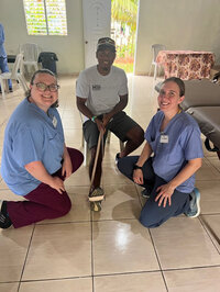two doctor students sitting next to guy on mission trip