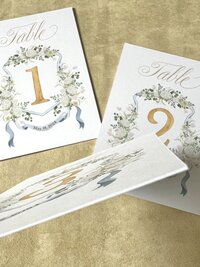 A set of 15 wedding table number cards featuring the client's wedding crest by Alicia Betz of The Welcoming District.