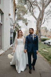 bride and groom stand outside of cool shop in fitzroy