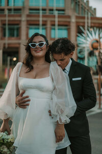 bride in retro glasses and room kissing her shoulder