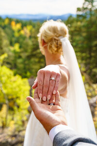 Close-up of the bride holding hands with her partner and showing her ring during a Colorado mountain elopement.