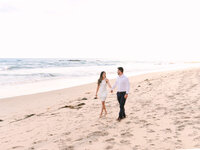couple walking along laguna beach coastline