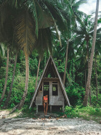 Woman standing by a beach shack