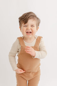 toddler boy in brown jumper laughing at camera in portland baby portrait studio - Ashlie Behm Photography