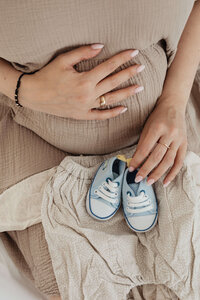 pregnant mom holding newborn clothes