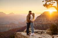Couple sharing a moment after the proposal, with the sweeping vistas of the Grand Canyon in the background.