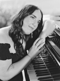 Black and white image of Mikaela Kahn live wedding vocalist at her piano