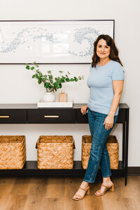 Dena smiling while standing inside her therapy practice