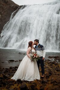 Bride & groom kissing in front of waterfall in Iceland!