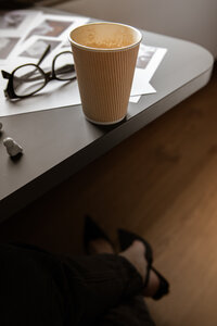 A to go coffee on the edge of the table 