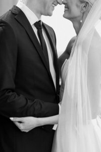 black and white image bride and groom holding hands
