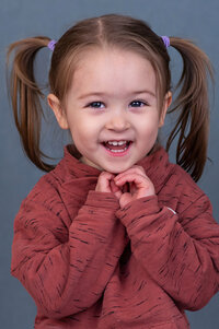 Girl posing with a big smile for her preschool photo in Vancouver