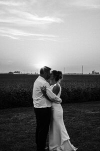 Bride and groom at sunset kissing