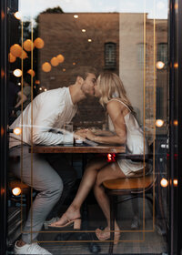 Engaged couple kissing inside a cozy bistro in Chicago