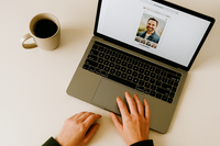 Flat lay of a laptop displaying an online photo gallery with a client browsing dating app images, representing included image delivery with online dating photography packages in Minneapolis.