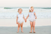 Toddler sisters on the beach in Wrightsville Beach, NC