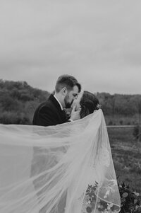 fallback shared on Invalid Date | bride and groom kissing while standing in a field