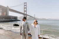 couple posing in front of bridge
