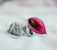 Bride and Groom rings pictured with a red leaf