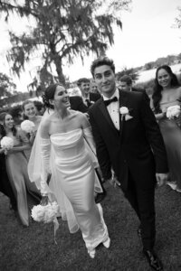couple walking towards the camera with their bridal party behind them
