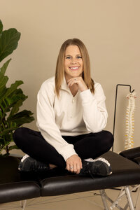 Branding photo of a small business owner and chiropractor in a modern studio, showcasing a professional and approachable look.