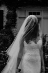 black and white blurry image of bride with veil over her face