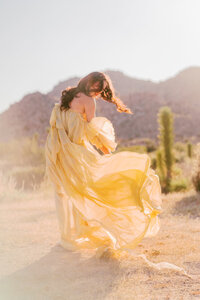 woman wearing flowy yellow dress in the desert