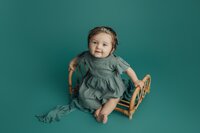 6 month girl on teal during milestone session in land o lakes