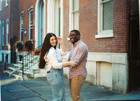 man and woman laugh while strolling the streets of philadelphia