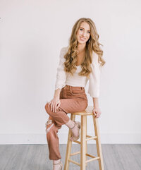 Headshot of Katherine, founder of Anne-Marie Designs, seated and smiling