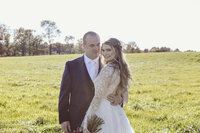 A wedding couple posing in a field