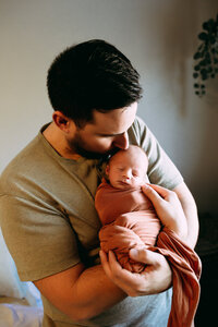 Dad holding swaddled baby for Ottawa Newborn Photography session