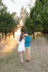 couple kissing in a row of trees taken by engagement photographers nashville tn