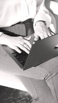 Amare Creative co-founder working with a laptop in black-and-white.