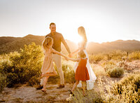 family playing in the desert for portraits in phoenix arizona with their photographer Amber
