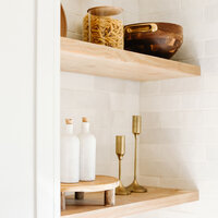 Floating wood shelves with candles and decor, highlighting elegant home styling ideas.
