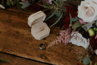 Wedding rings on rustic table At The Bluff venue