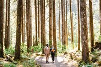 Groom and Groom holding hands in the trees by wedding coordinator near me