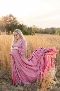 Expecting mom holding her belly during maternity photoshoot.