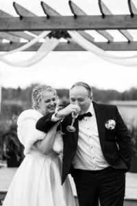 Wedding couple celebrating with a glass of champagne after their elopement in their own backyard