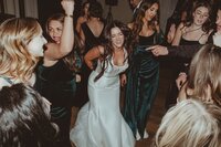 Group of women dancing and smiling at a wedding