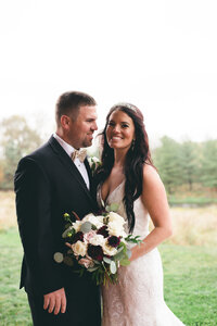 Bride and Groom with a white and deep red bouquet by Prose Florals