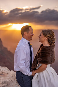 A bride and groom exchanging vows with the Grand Canyon sunset casting warm golden hues across the scene.
